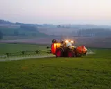 Ciągnik z opryskiwaczem na polu, precyzyjne dawkowanie roundup.