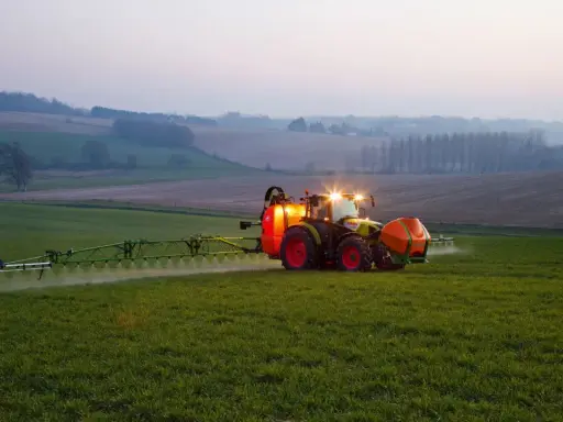Ciągnik z opryskiwaczem na polu, precyzyjne dawkowanie roundup.